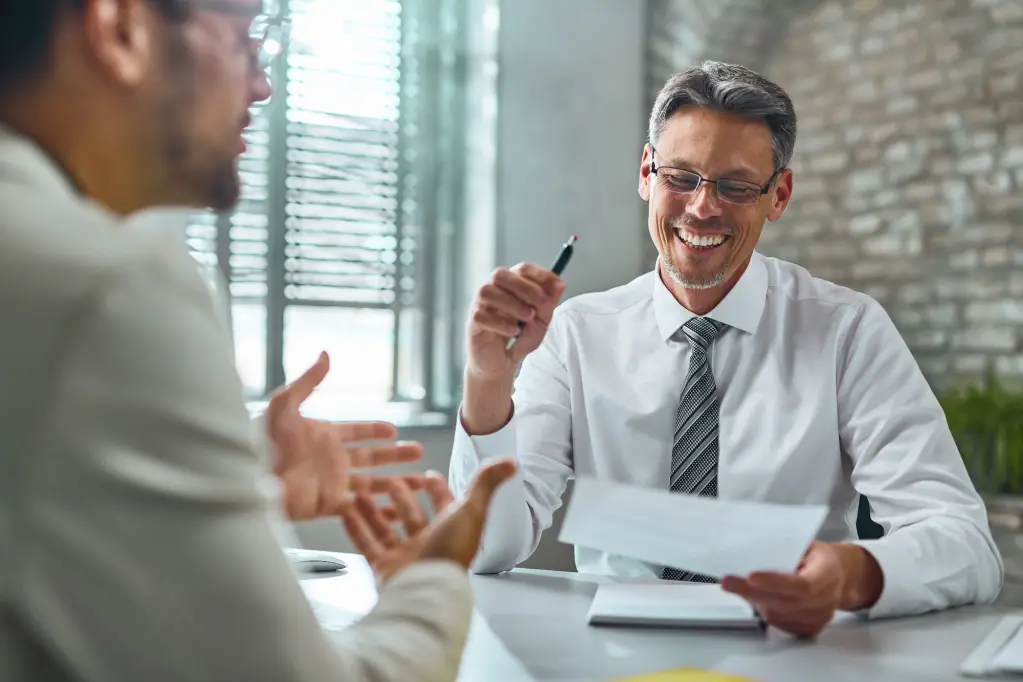 happy-entrepreneur-reading-candidate-s-cv-during-job-interview-in-the-office-